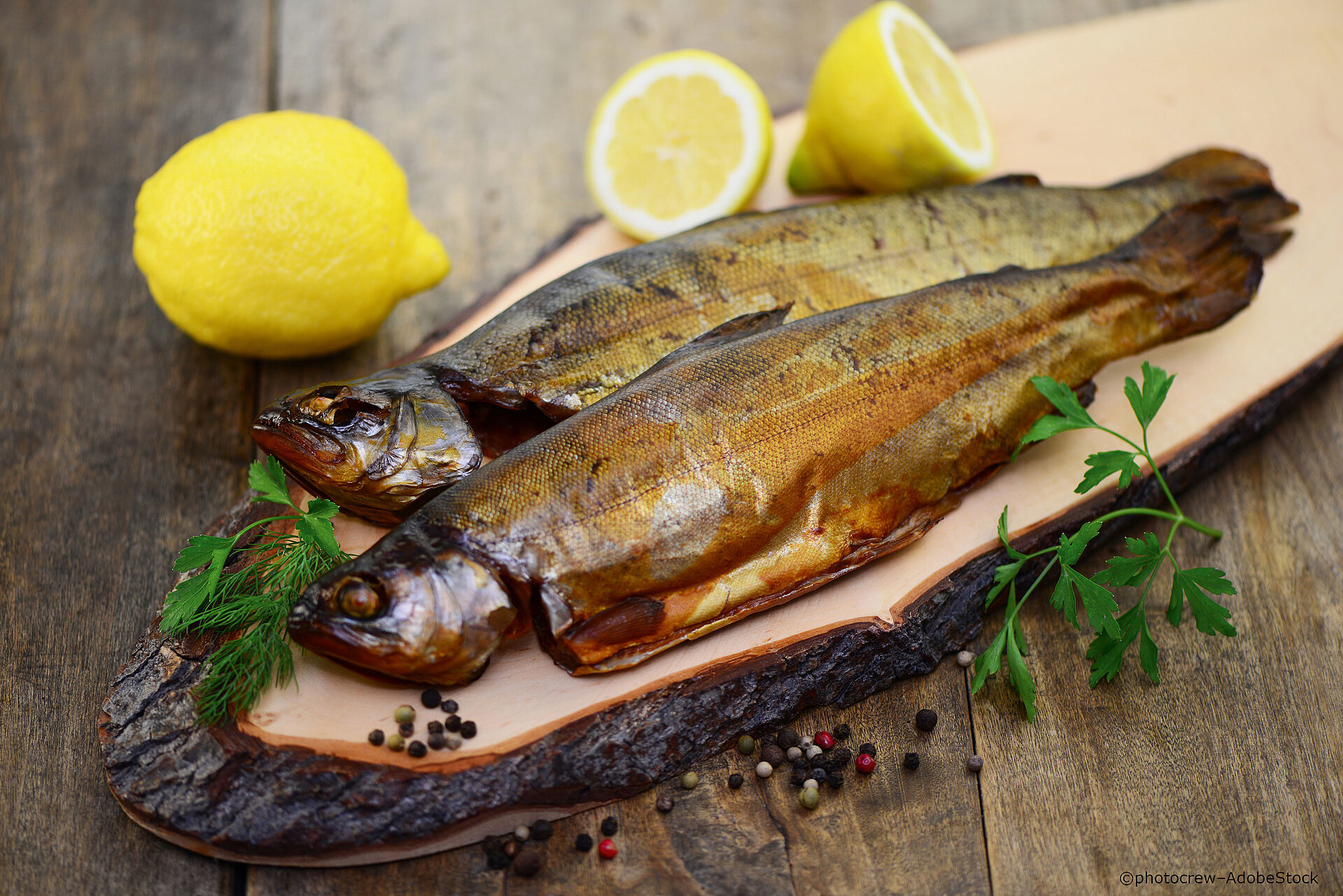 Räucherfisch auf Holzbrett mit Zitrone regionale-kueche-fisch-mit-zitrone
