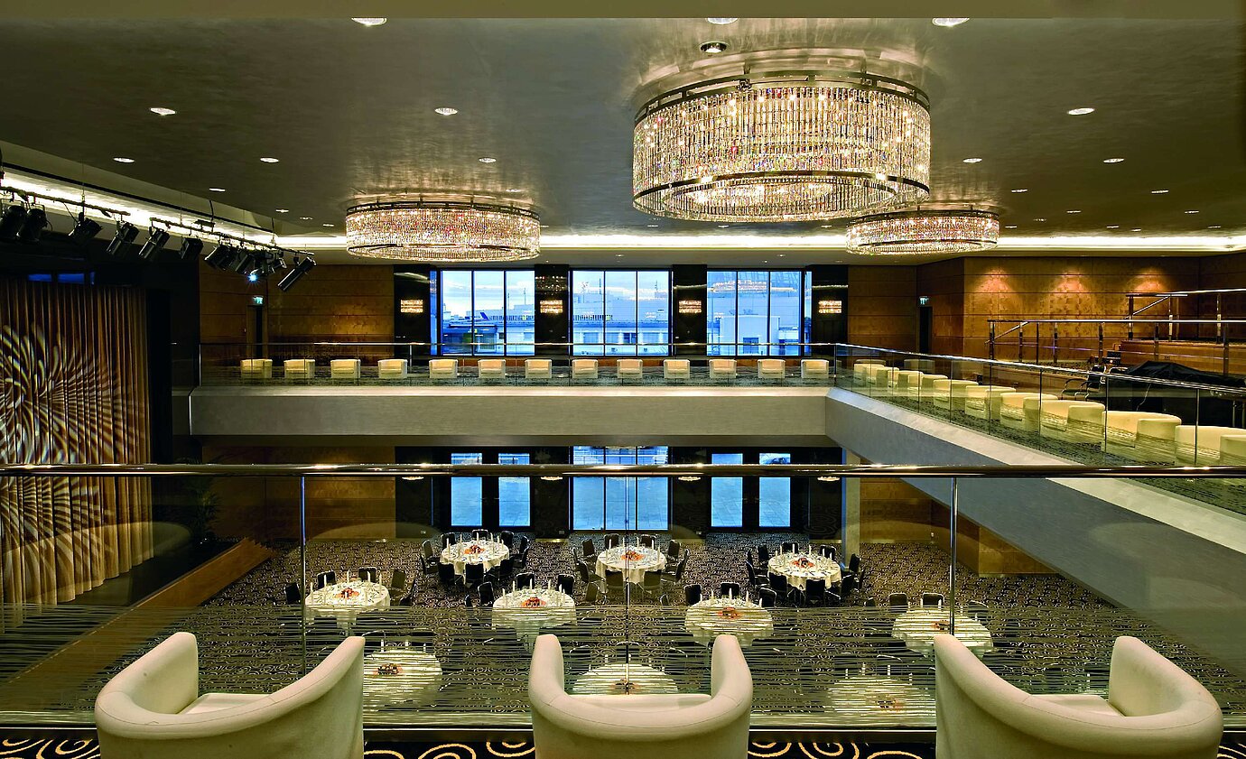 Eleganter Saal im Maritim Hotel Düsseldorf mit beeindruckenden Kronleuchtern, moderner Architektur und großer Bühne.