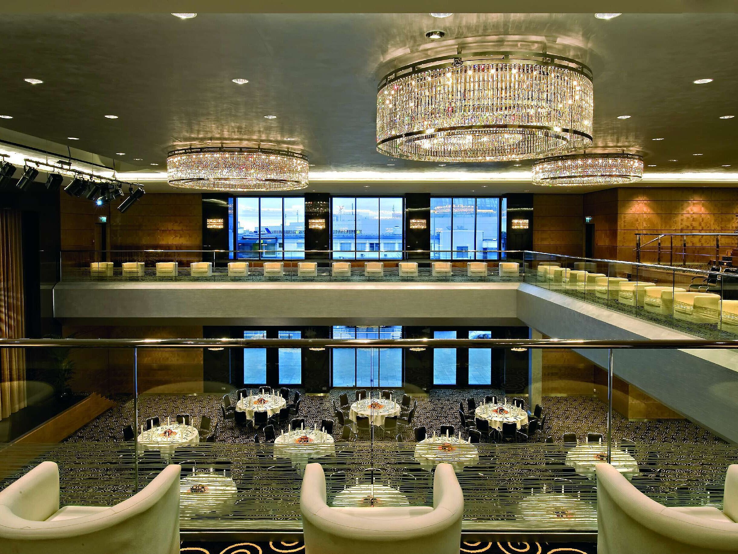 Eleganter Saal im Maritim Hotel Düsseldorf mit beeindruckenden Kronleuchtern, moderner Architektur und großer Bühne.