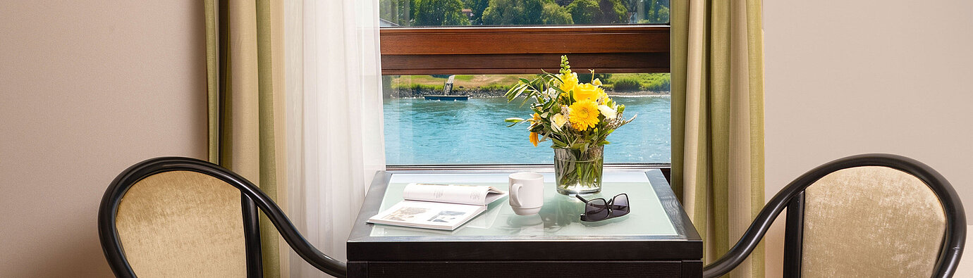 Junior Suite Tisch mit Sitzgelegenheiten am Fenster der Junior Suite im Maritim Hotel Königswinter mit Blick auf den Rhein.