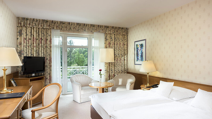 Helles Doppelzimmer mit Balkonblick und Sitzecke im Maritim Hotel Bad Wildungen