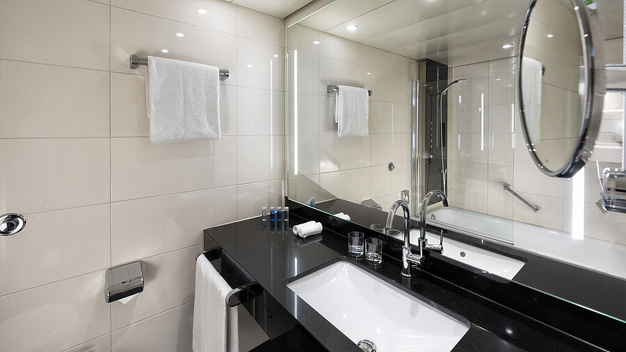 Modernes Badezimmer im Maritim Hotel Ulm mit Wannenbad und stilvoller Beleuchtung.