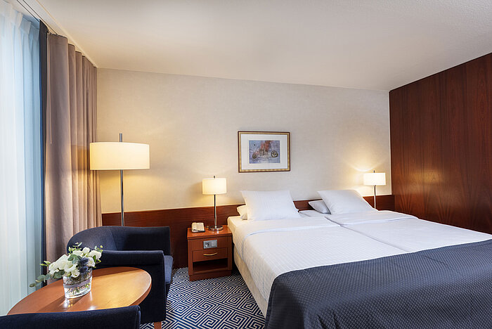 Klassisches Doppelzimmer im Maritim Hotel Würzburg mit hellem Ambiente und gemütlicher Sitzecke