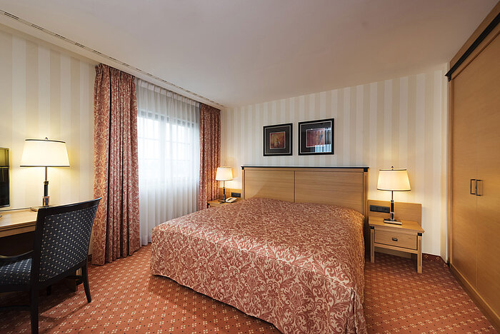 Junior Suite im Maritim Hotel Dresden mit großzügigem Bett, Schreibtisch und eleganter Einrichtung.