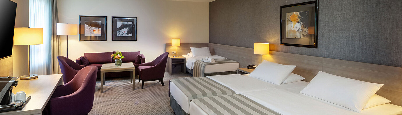 Classic Familienzimmer Classic Familienzimmer im Maritim Hotel Königswinter mit Doppelbett, Schlafsofa und gemütlicher Sitzecke.