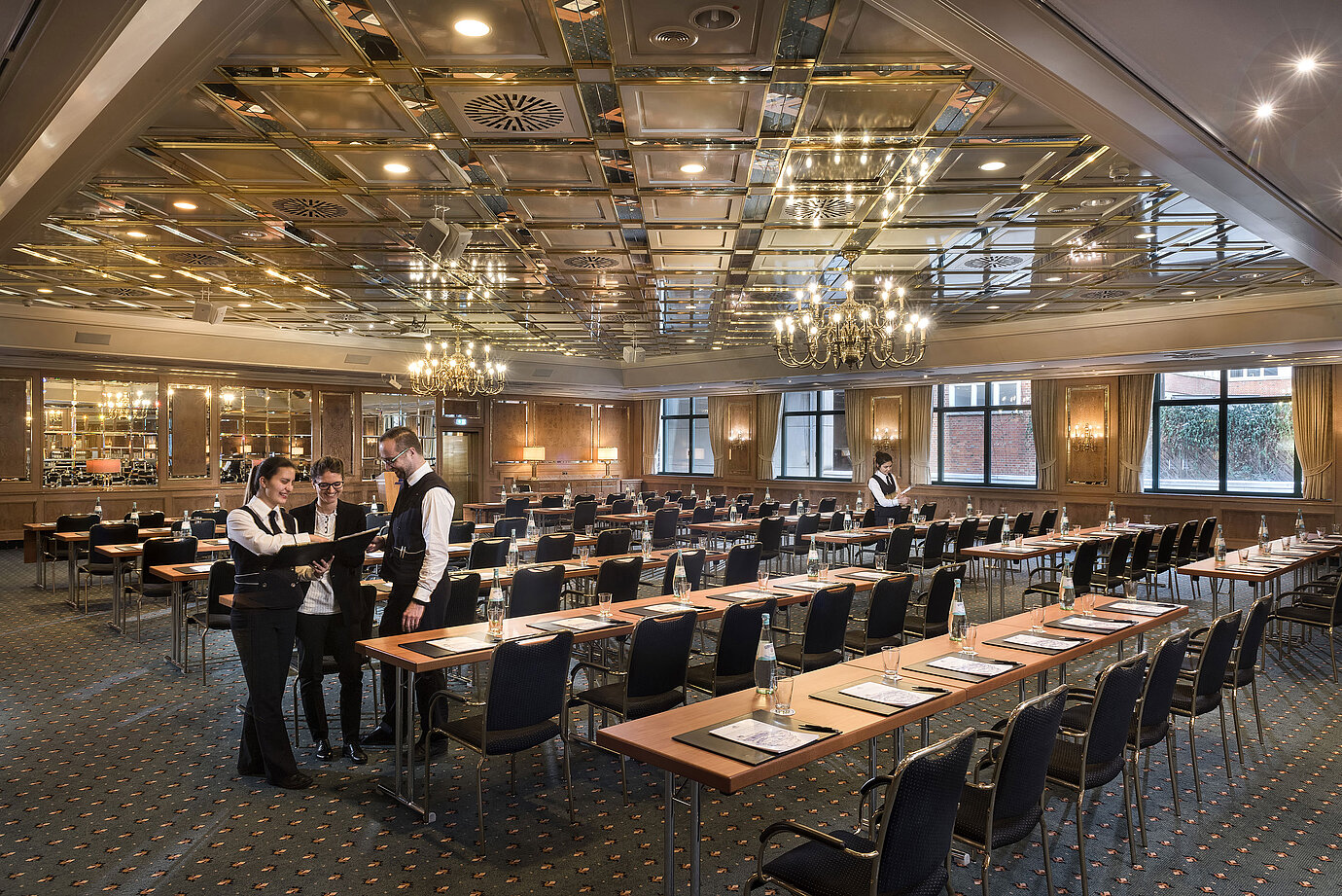 Zwei Mitarbeitende bereiten einen Konferenzraum mit Reihenbestuhlung im Maritim Hotel Stuttgart vor