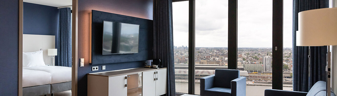Moderner Wohnbereich mit Stadtblick und TV im Maritim Hotel Amsterdam