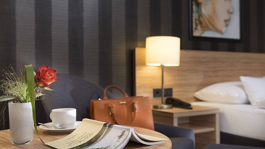 Stilvolle Tischdekoration im Maritim Hotel Königswinter mit Rose, Tasche und gemütlicher Atmosphäre.