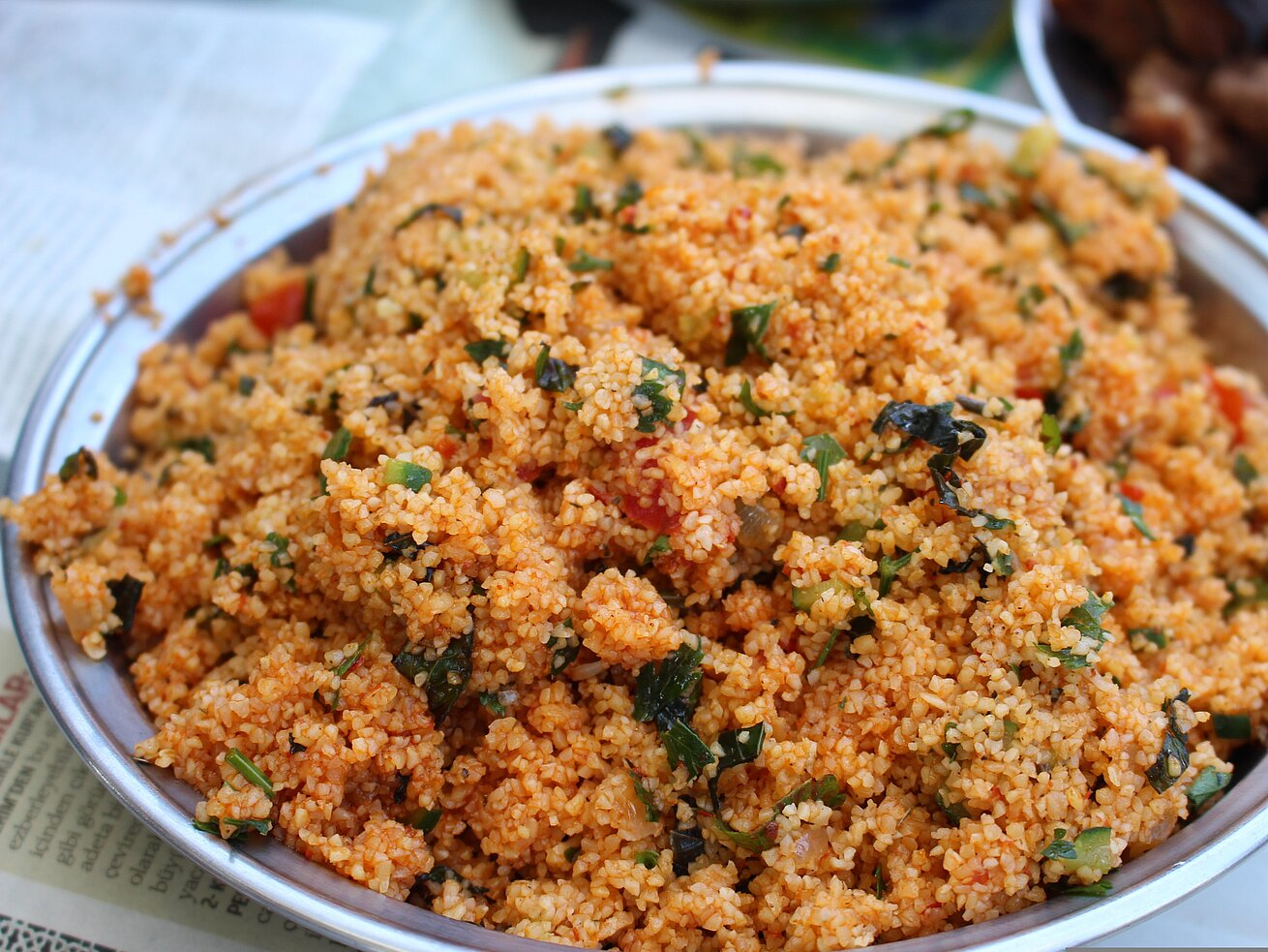 Frisch zubereiteter Bulgur mit Kräutern in einer Schale angerichtet.