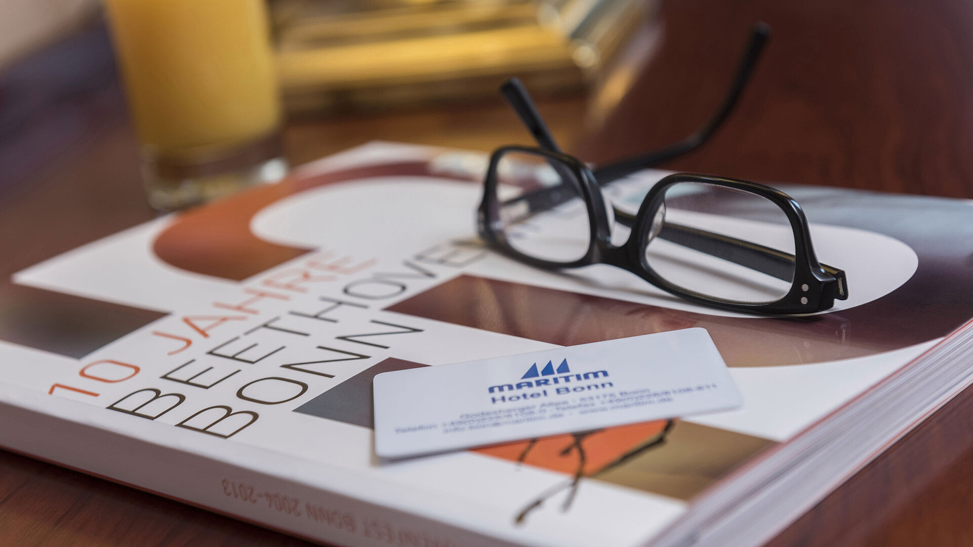Detailaufnahme aus einem Zimmer im Maritim Hotel Bonn mit Brille, Hotelkarte und einem Buch über Beethoven.