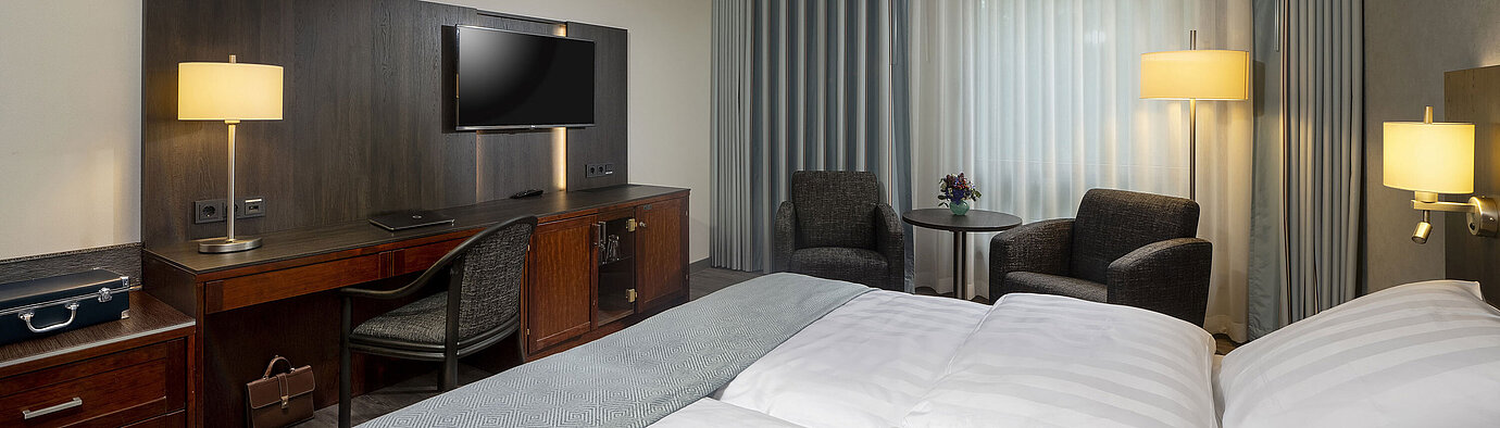 Classic Zimmer Elegantes Doppelzimmer im Maritim Hotel Bremen mit moderner Einrichtung, bequemen Betten und gemütlichem Sitzbereich.