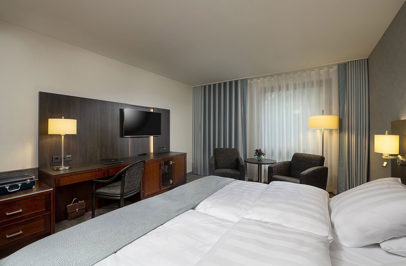 Elegantes Doppelzimmer im Maritim Hotel Bremen mit moderner Einrichtung, bequemen Betten und gemütlichem Sitzbereich.
