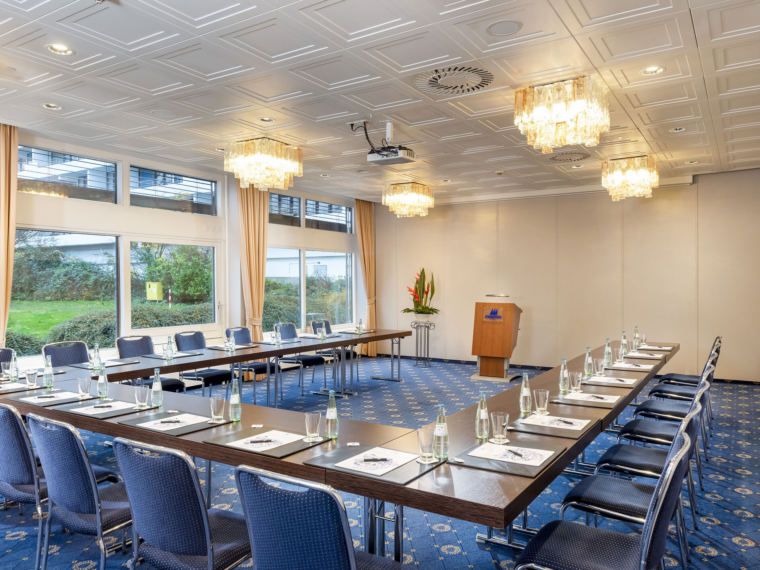 Der Salon Lübeck im Maritim Hotel Kiel, ein moderner Konferenzraum mit U-förmiger Bestuhlung, großen Fenstern und Kronleuchtern.