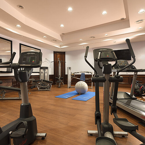Moderner Fitnessraum mit Cardiogeräten, Hanteln und Yogamatten im Maritim Hotel Ulm.