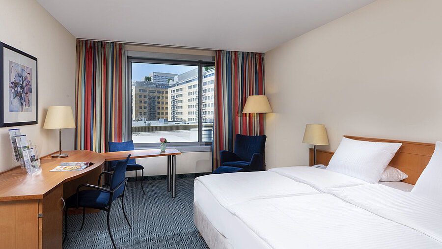 Classic Zimmer im Maritim Hotel Frankfurt mit gemütlichem Doppelbett, Schreibtisch und Stadtblick.