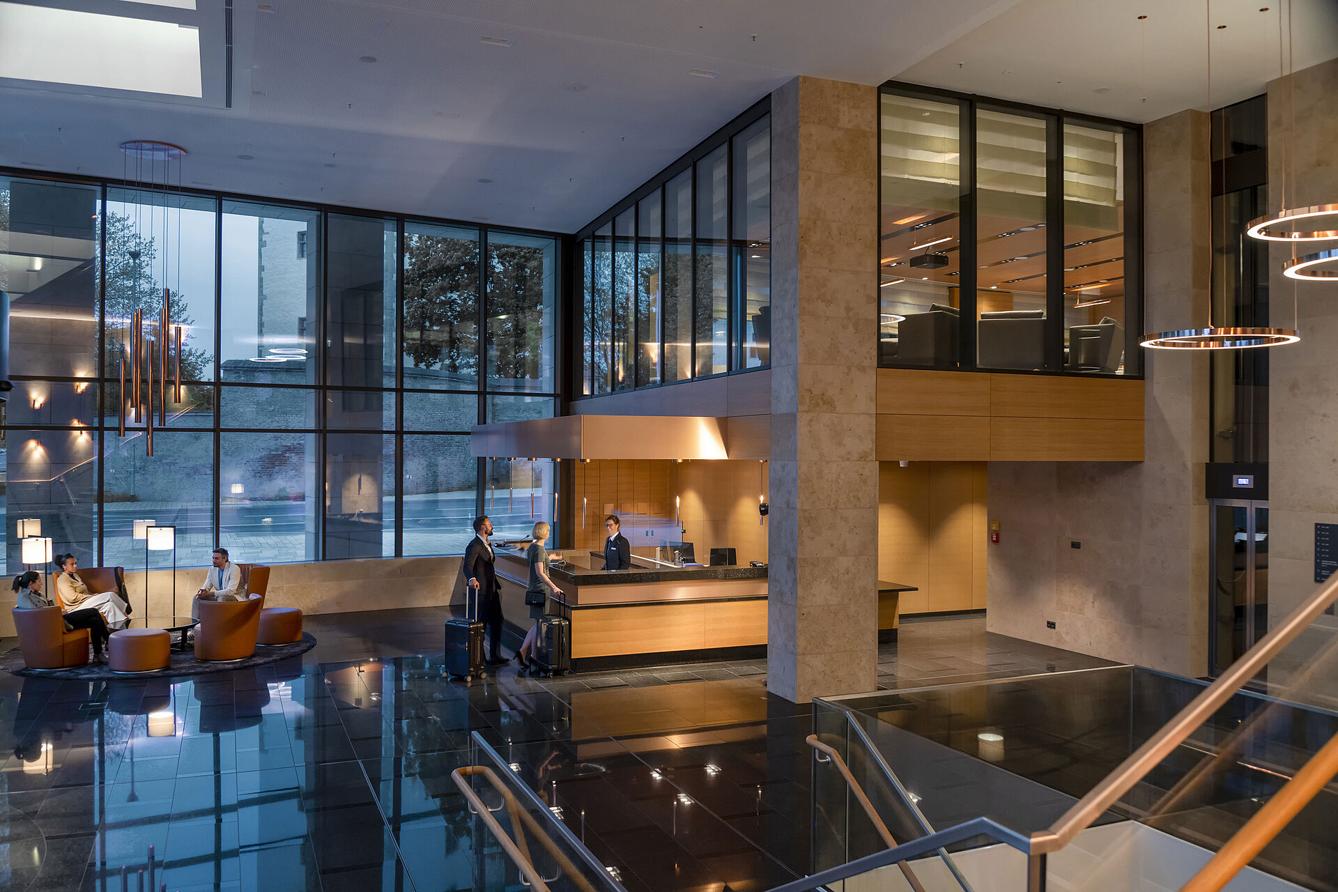 Die moderne Lobby des Maritim Hotel Ingolstadt mit hohen Glasfenstern, Rezeption und gemütlichen Sitzbereichen.