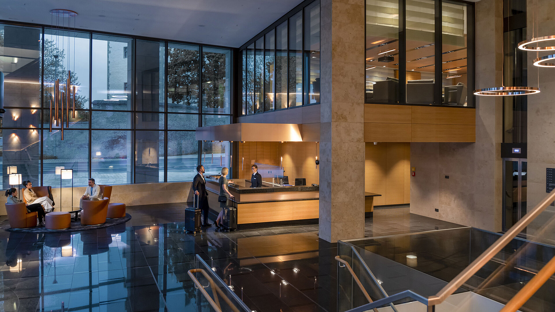 Die moderne Lobby des Maritim Hotel Ingolstadt mit hohen Glasfenstern, Rezeption und gemütlichen Sitzbereichen.