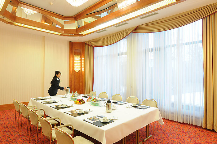 Eleganter Besprechungsraum mit Tageslicht, gedecktem Tisch und warmem Ambiente im Maritim Hotel Magdeburg.
