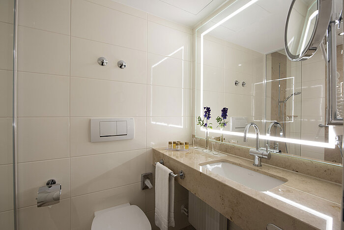 Helles Badezimmer mit großem Spiegel und Pflegeprodukten im Maritim Hotel Titisee