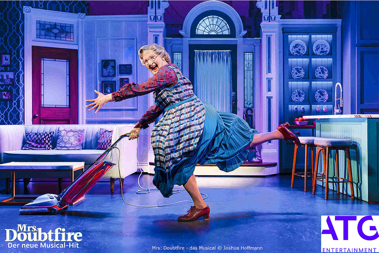 Szene aus Mrs Doubtfire Musical mit Figur beim Staubsaugen auf Bühne