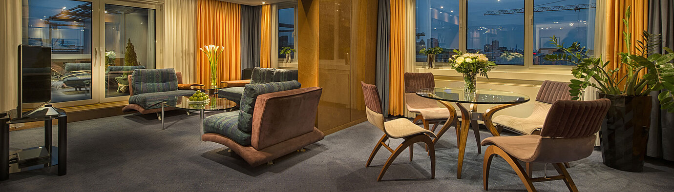 Elegantes Wohnzimmer in der Präsidenten-Suite im Maritim proArte Hotel Berlin mit stilvoller Beleuchtung und Aussicht.