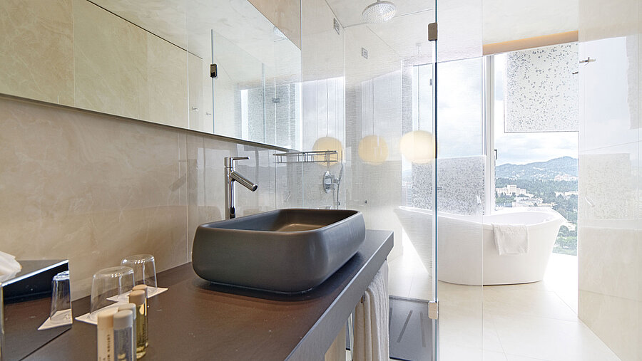 Helles Bad mit Designerwaschbecken, freistehender Badewanne und Ausblick im Maritim Hotel Plaza Tirana
