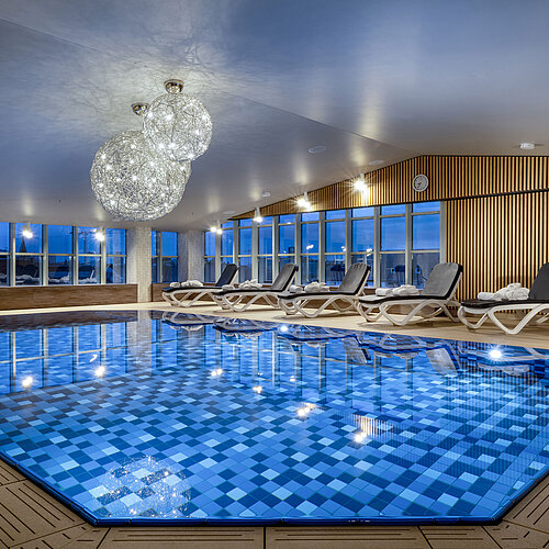 Wellnessbereich mit Liegen und Schwimmbad im Maritim Hotel München
