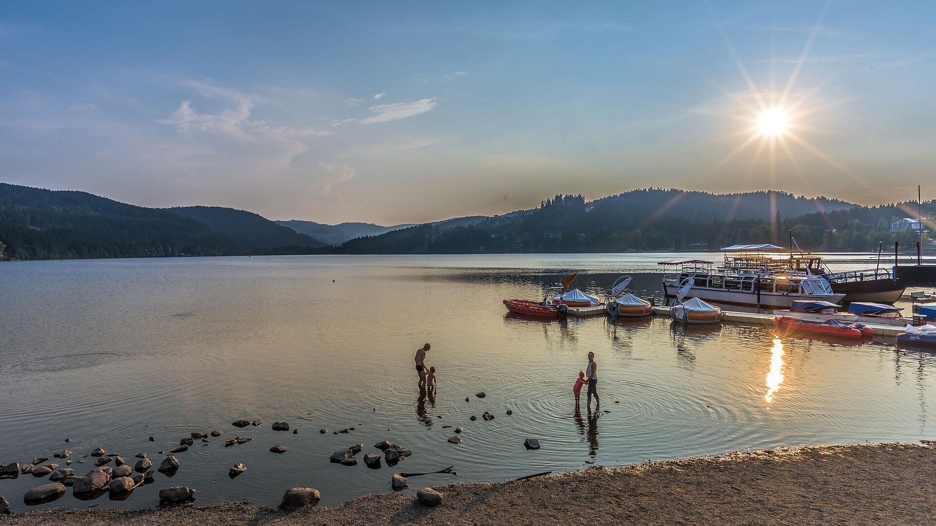 Titisee Sonnenuntergang am Titisee mit Badenden und Booten direkt am Maritim Hotel Titisee.