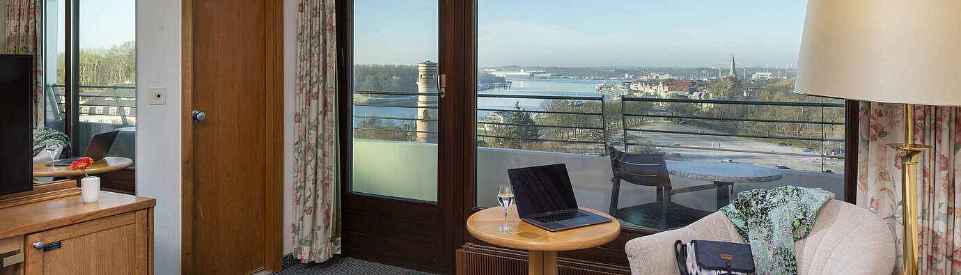Classic Einzelzimmer Helles Hotelzimmer mit Balkon, Schreibtisch und Ausblick auf die Trave und die Lübecker Bucht