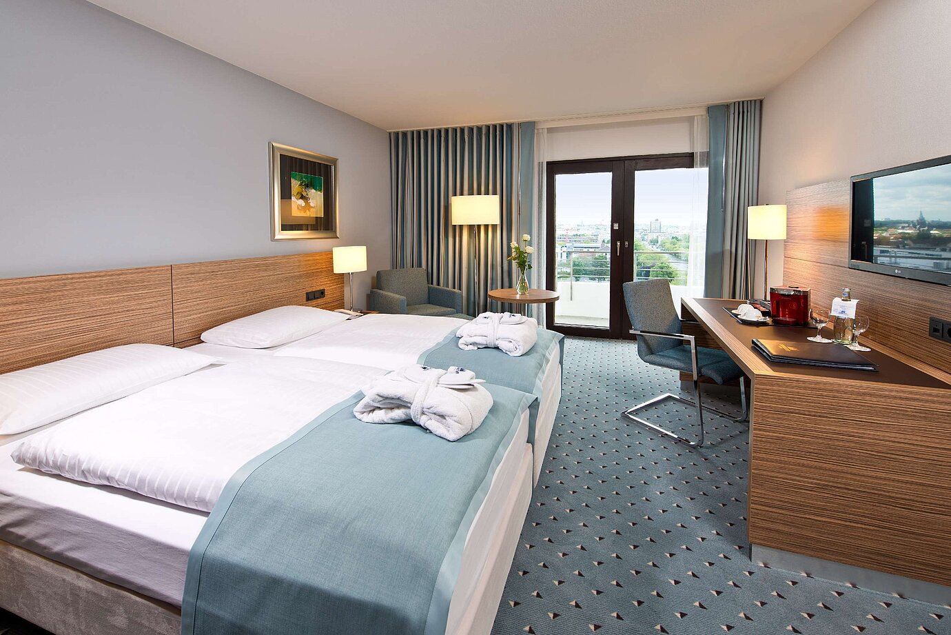 Superior Zimmer im Maritim Hotel Darmstadt mit stilvollem Design, Schreibtisch, Sitzecke und Doppelbett mit Bademänteln.