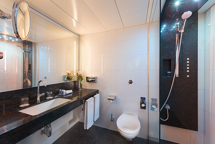 Geräumiges Bad mit Dusche, WC, Spiegel und Granitwaschtisch im Maritim Hotel Stuttgart