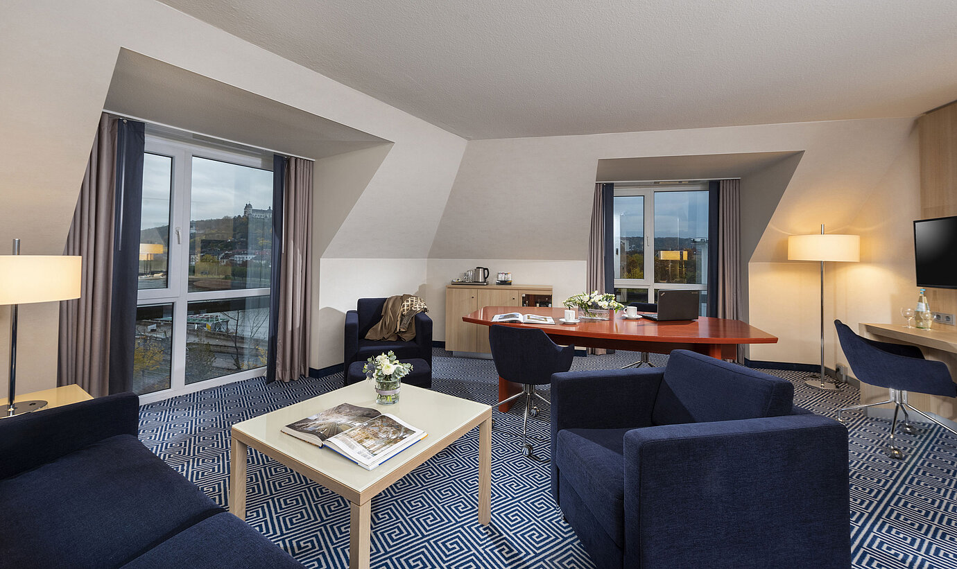 Großzügige Grand Suite im Maritim Hotel Würzburg mit Sitzecke und Blick auf die Festung Marienberg
