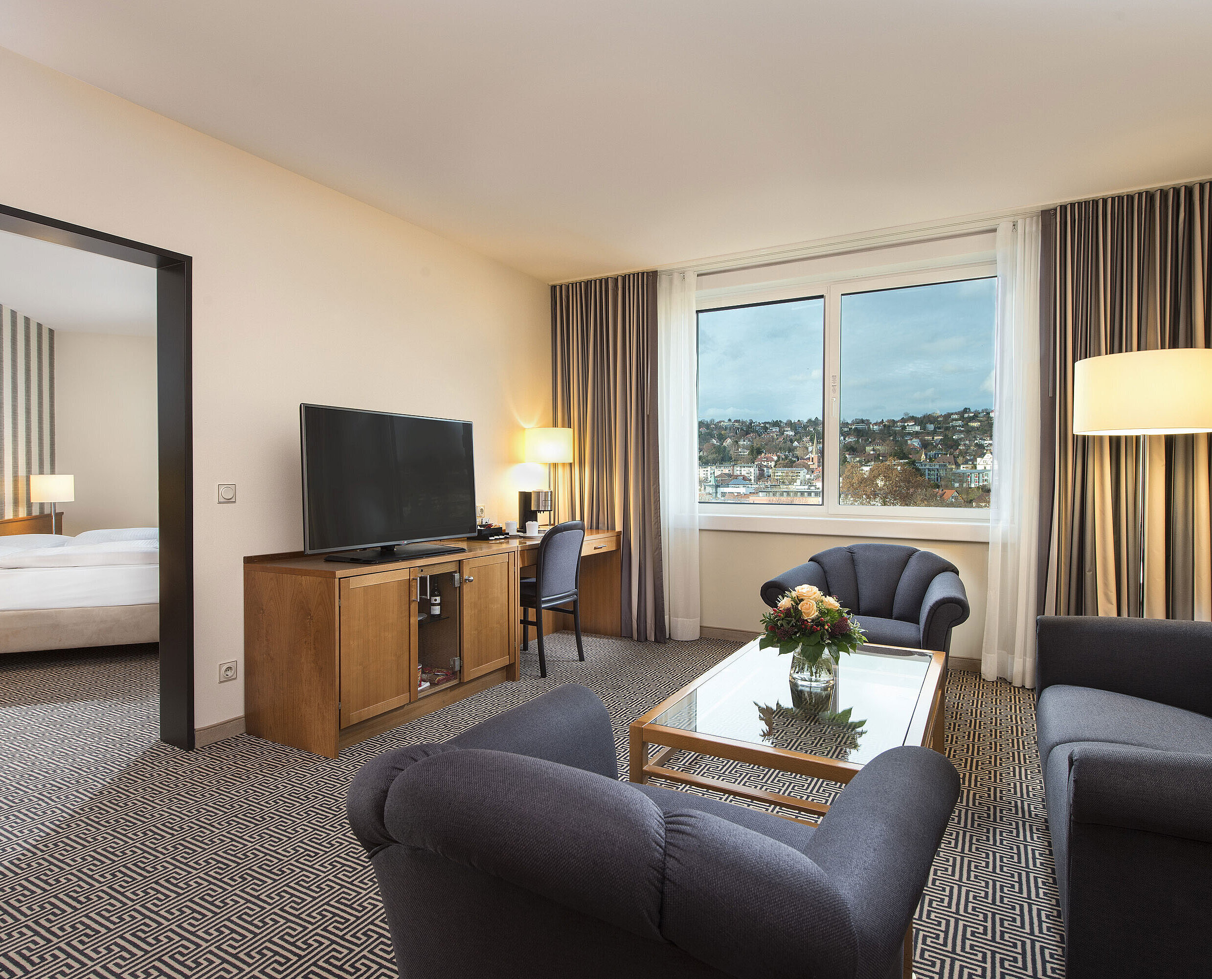 Helle Suite mit Stadtblick, Sofas, TV, Schreibtisch und Schlafzimmer im Maritim Hotel Stuttgart