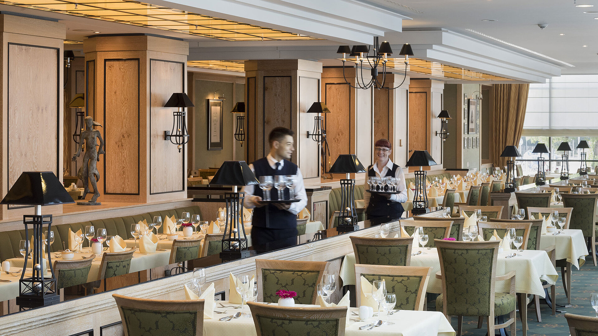 Restaurant 'Wintergarten' im Maritim Hotel Dresden mit gedeckten Tischen und freundlichem Servicepersonal.