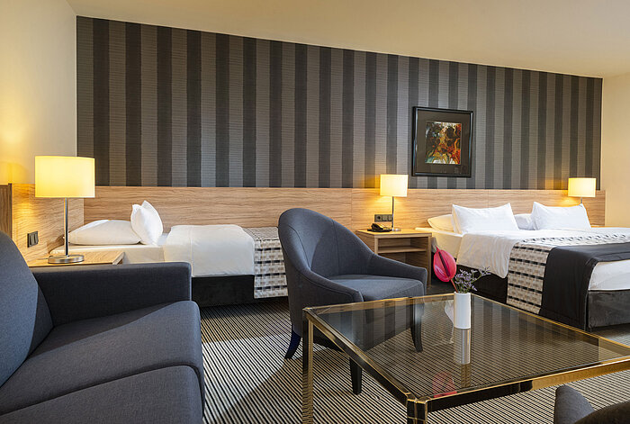 Modernes Familienzimmer mit stilvollem Design und gemütlicher Sitzecke im Maritim Hotel Königswinter.
