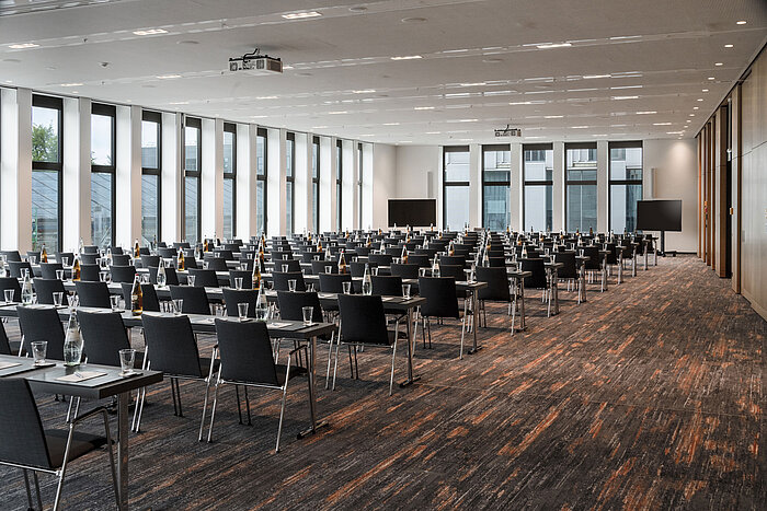 Großer Konferenzraum im Maritim Hotel Ingolstadt mit Reihenbestuhlung, bodentiefen Fenstern und hochwertiger Technik.