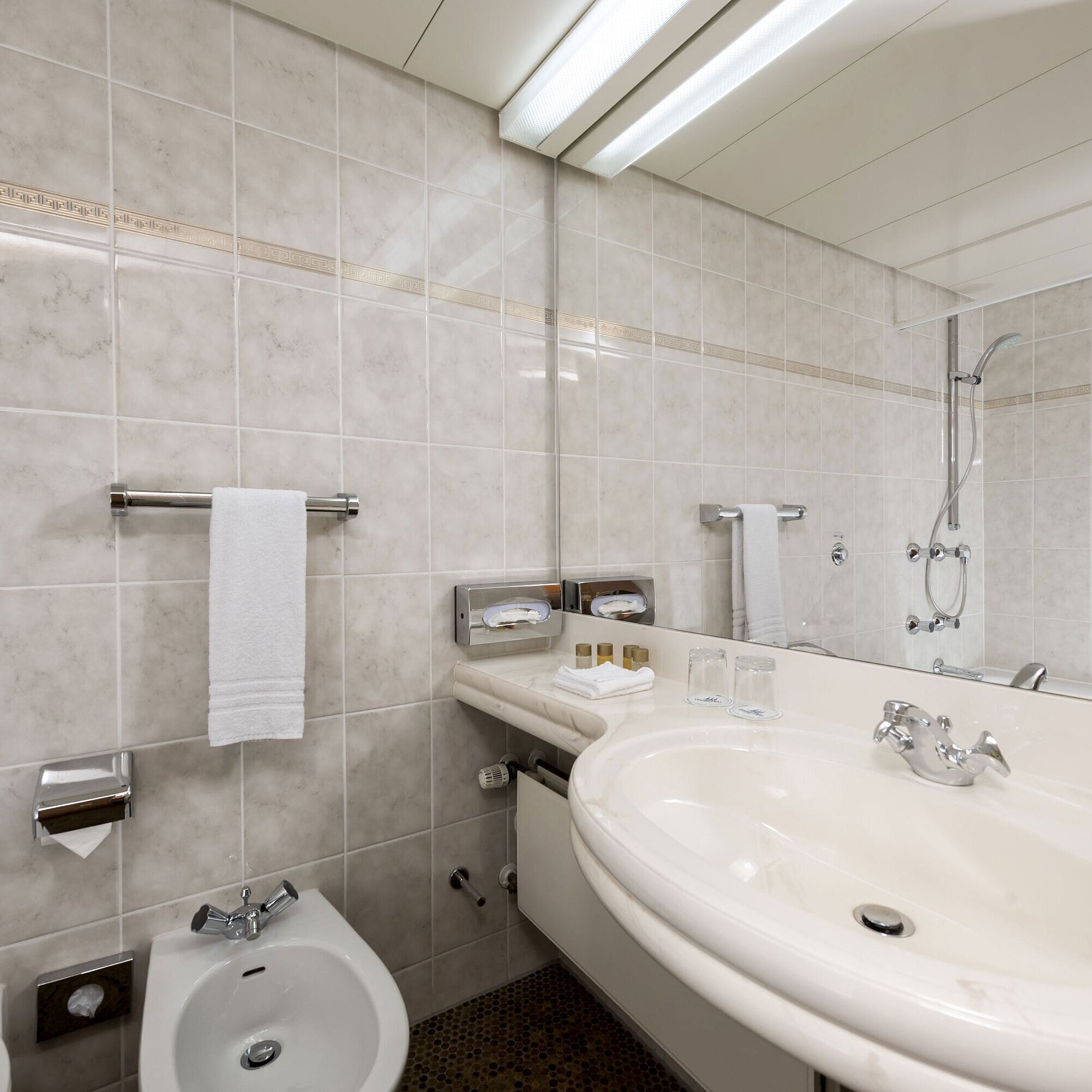 Badezimmer Helles Badezimmer mit Bidet, Waschbecken, Spiegel und frischen Handtüchern im Maritim Hotel Bad Wildungen