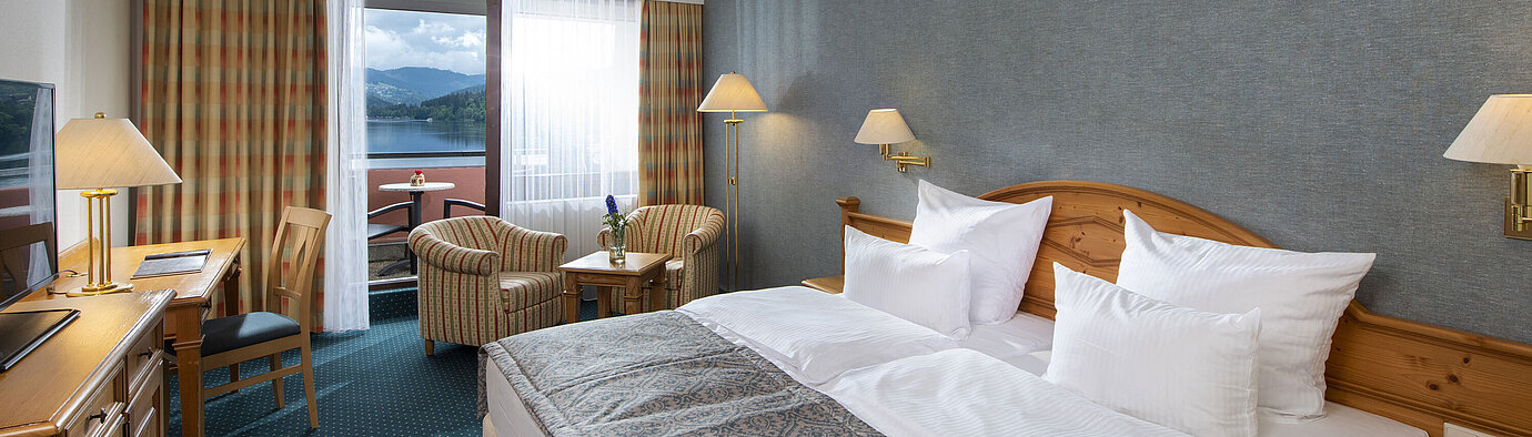 Geräumiges Zimmer im Maritim TitiseeHotel mit Sitzgruppe und Blick auf den Titisee