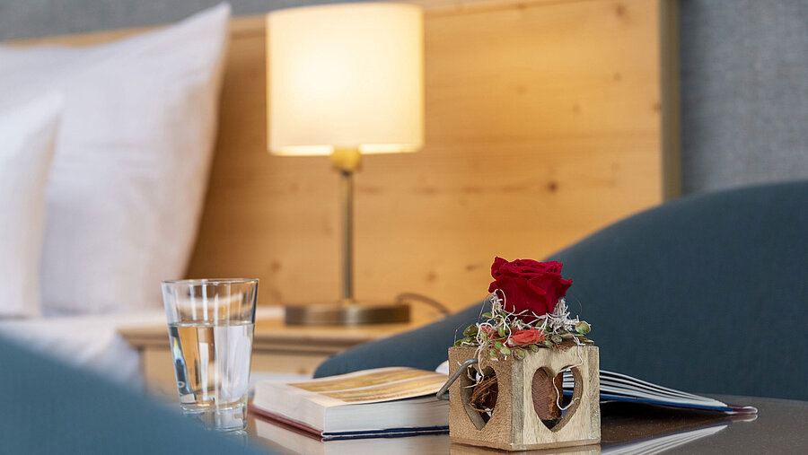 Rote Rose in Holzvase mit Herzmotiv im Zimmer des Maritim TitiseeHotels
