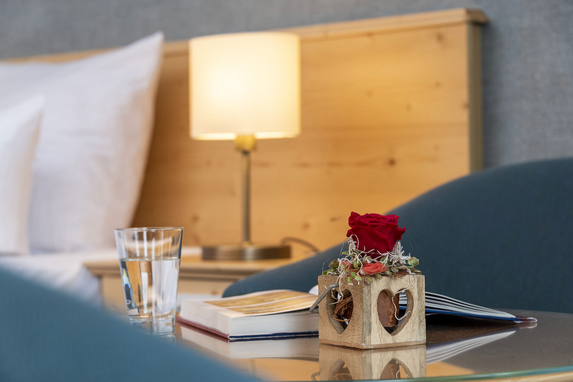Studio Rote Rose in Holzvase mit Herzmotiv im Zimmer des Maritim TitiseeHotels