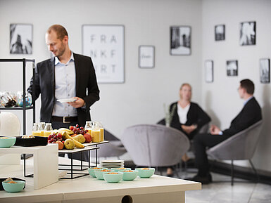Tagungspause im Maritim Hotel Frankfurt mit gesunden Snacks, frischem Obst und Saft in entspannter Lounge-Atmosphäre.