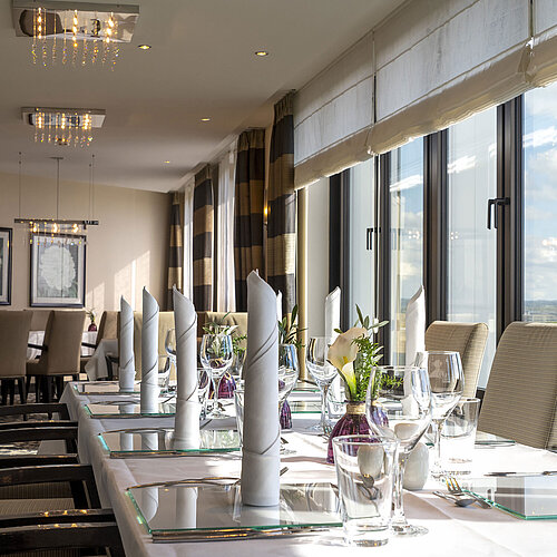 Elegante Tischdekoration in der VIP-Lounge des Maritim Hotel Düsseldorf mit großen Fenstern und stilvollem Ambiente.