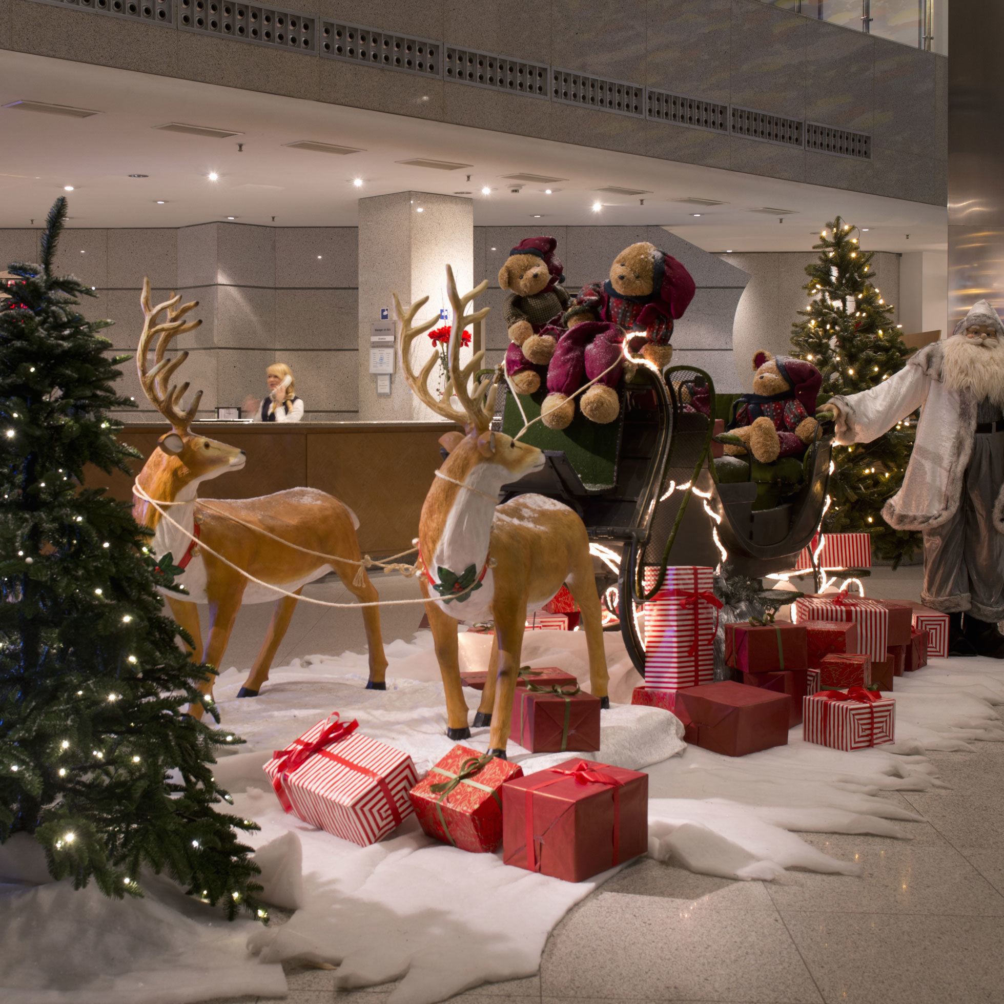 Festliche Dekoration in der Lobby des Maritim proArte Hotel Berlin mit Weihnachtsmann, Rentieren und Geschenken.