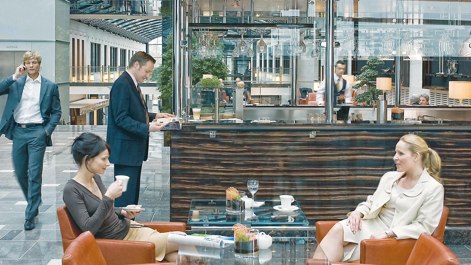 Helle Lobby im Maritim Hotel Düsseldorf mit Sitzgelegenheiten, Glasdach und modernem Cafébereich.