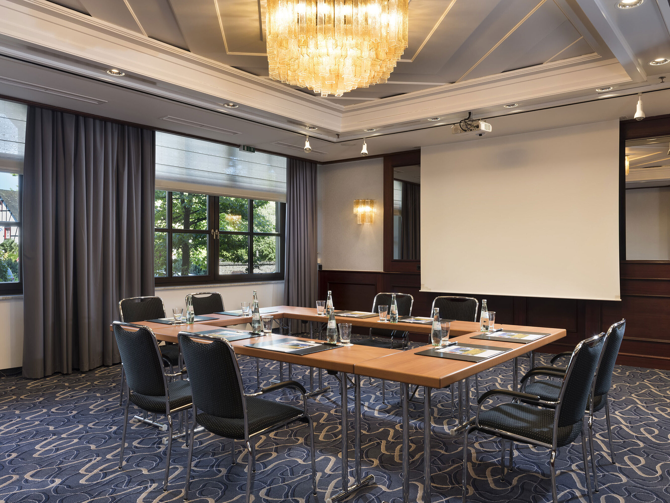 Heller Meetingraum mit moderner Technik, großen Fenstern und elegantem Kronleuchter im Maritim Hotel Königswinter.