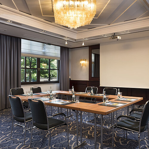 Heller Meetingraum mit moderner Technik, großen Fenstern und elegantem Kronleuchter im Maritim Hotel Königswinter.