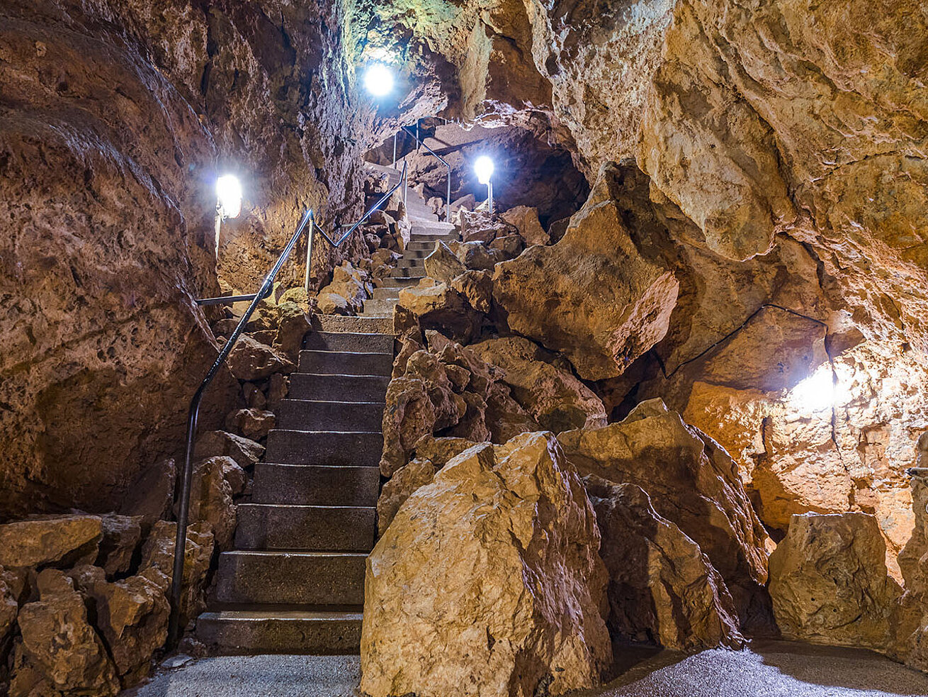 Tiefenhöhle Laichingen mit beleuchteter Steintreppe, Felswänden und Geländer – unterirdischer Aufstieg in natürlicher Grotte auf der Schwäbischen Alb