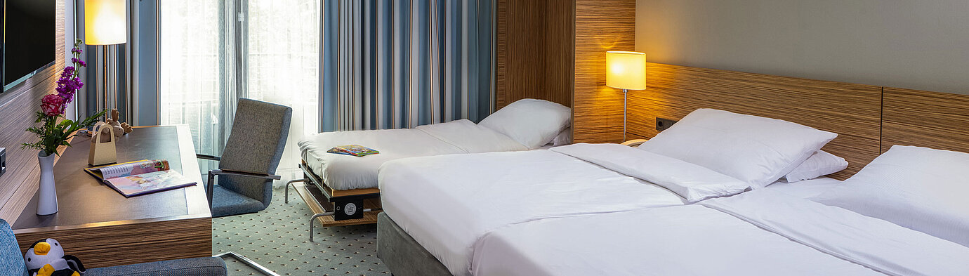 Comfort Familienzimmer im Maritim Hotel Darmstadt mit Doppelbett, Zustellbett und modernem Arbeitsbereich