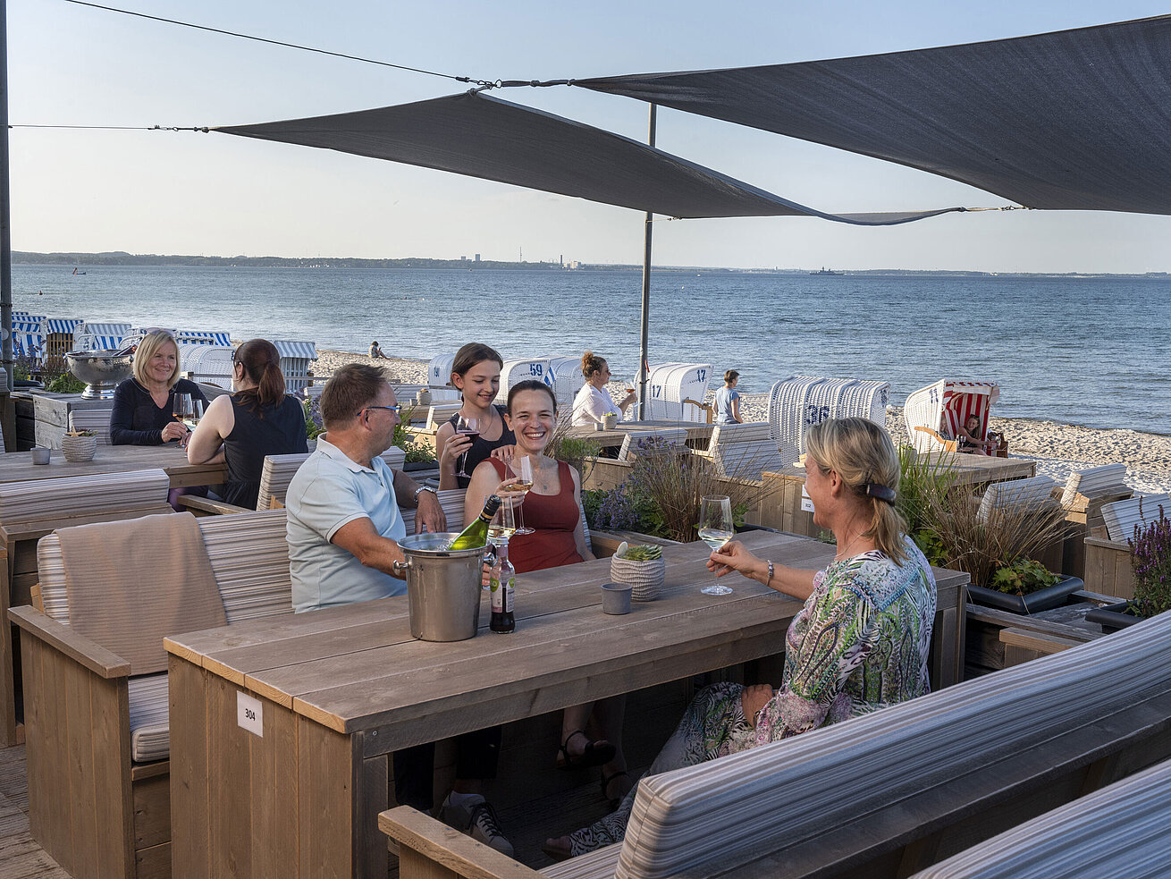 Beach Lounge Gruppe von Gästen in der Strandbar des Maritim Seehotel Timmendorfer Strand, genießt Drinks mit Meerblick und Strandkörben.