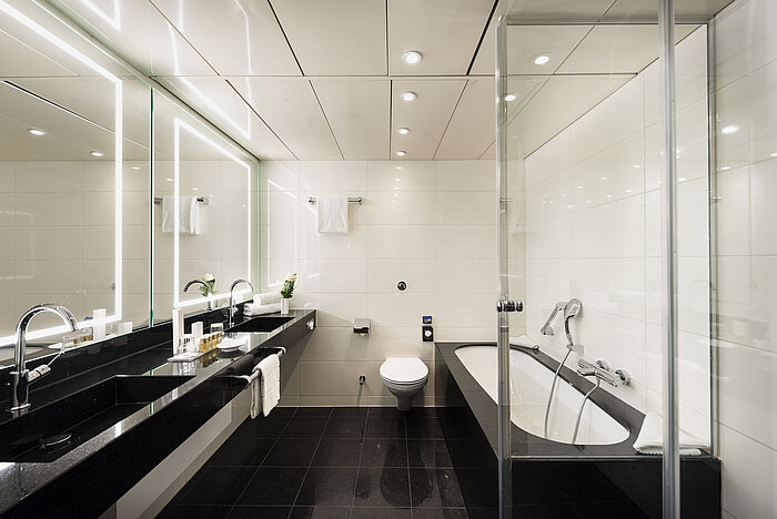 Elegantes Badezimmer mit Doppelwaschbecken, Badewanne und modernen Armaturen im Maritim Hotel Bonn, stilvoll und funktional.